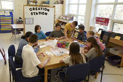 This is an image of students working together at a table .